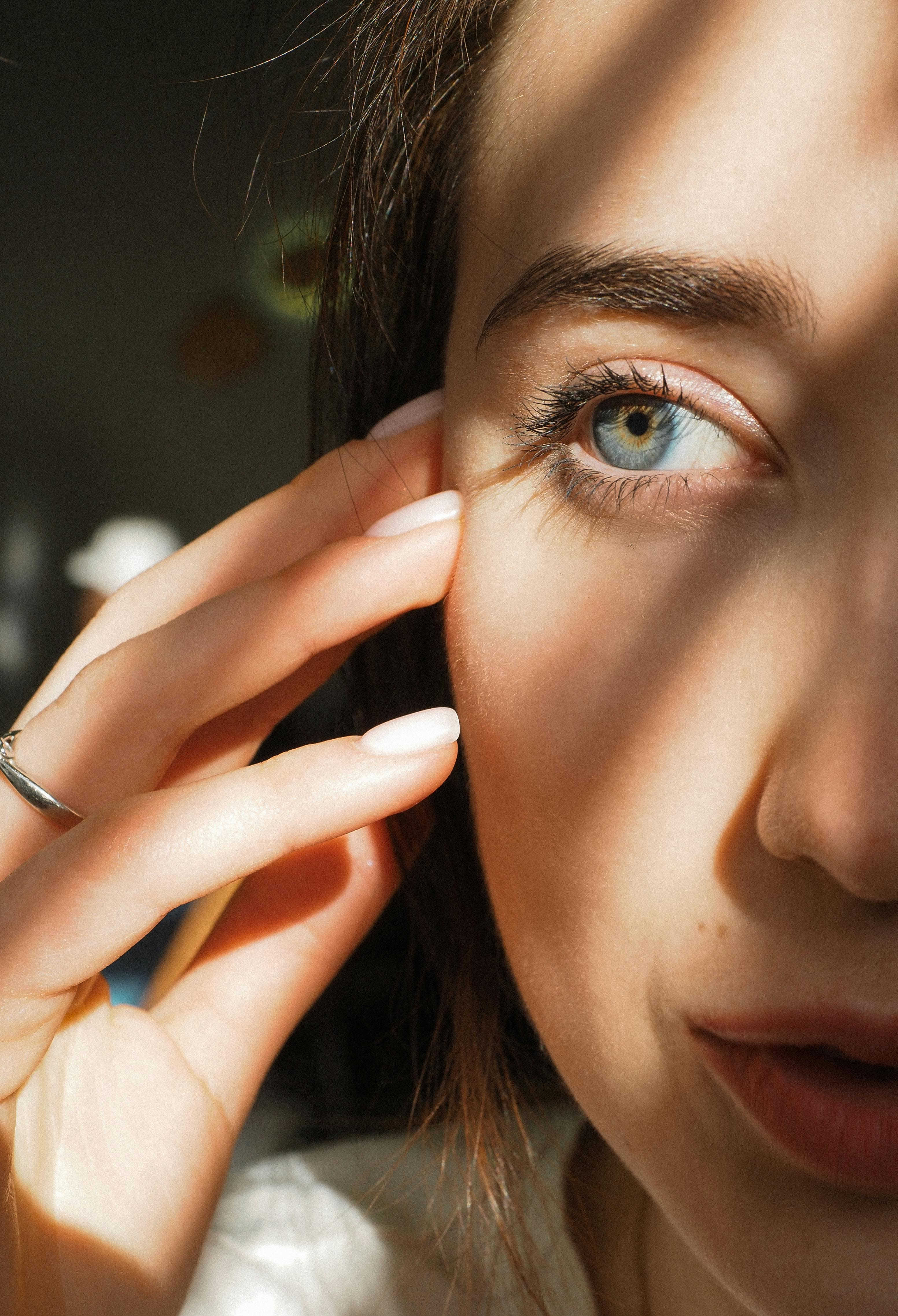 Kvinne som berører ansiktet sitt nær øyet